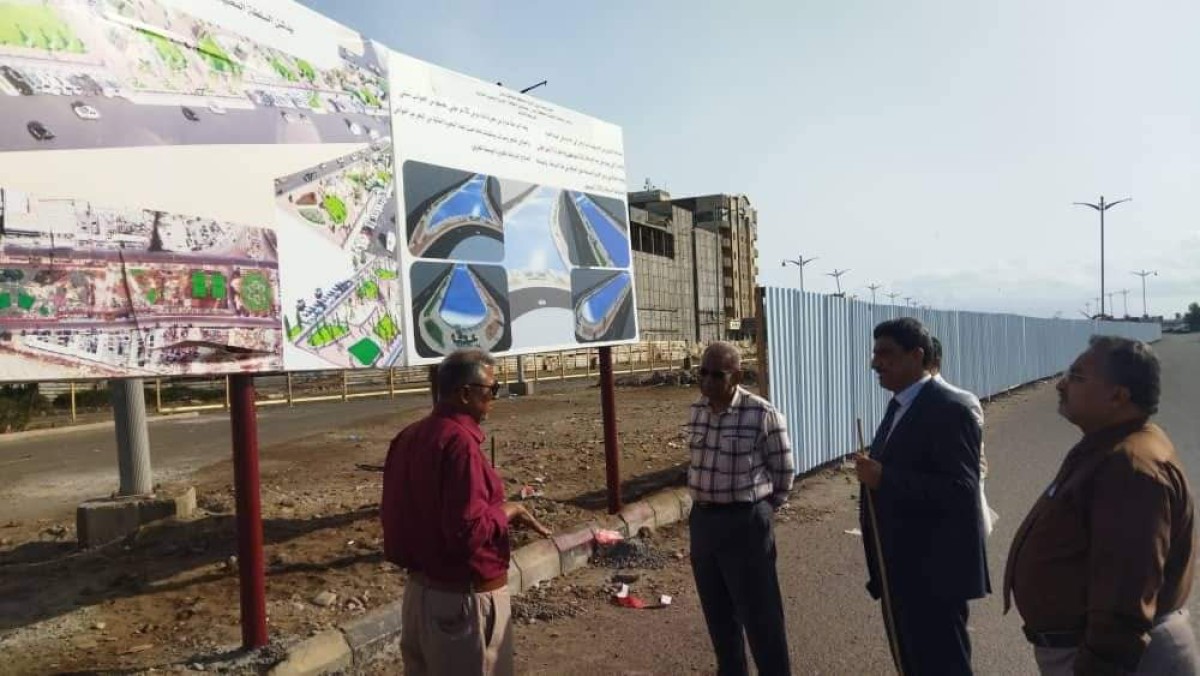 A government delegation reviews the progress of work on the project to remove waste and dust from the lake in Khor Maksar