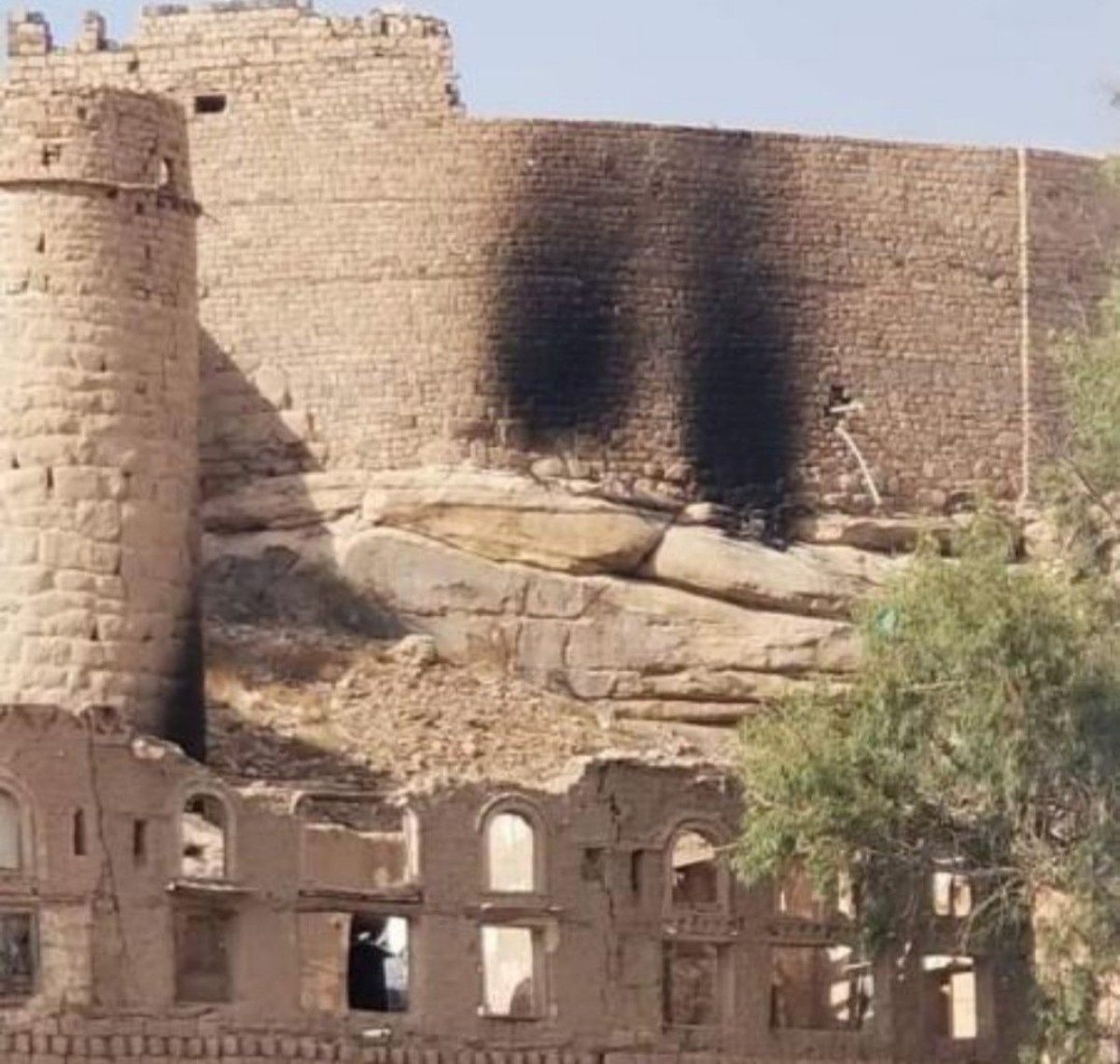 The Houthi militia burns part of the wall of the historic Radaa Castle in Al-Bayda